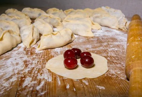 Main focus on pastry chef hand sculpting cherry dumplings. Process of cooking Stock Photos