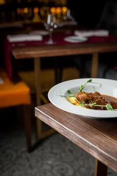 The main meat dish on a large deep plate. Restaurant Stock Photos