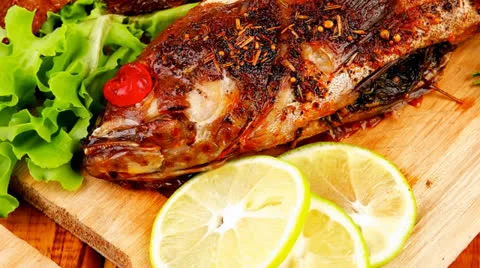 Main portion of two grilled fish served on wood Vídeos de archivo 24692975