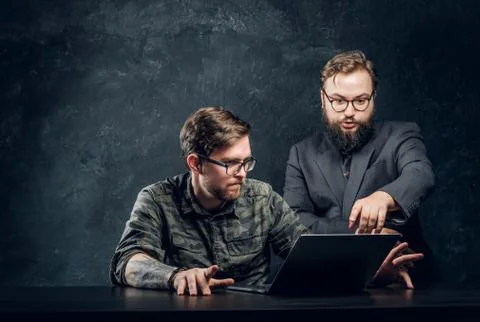 The main programmer of the company indicates errors to his subordinate in office Stock Photos