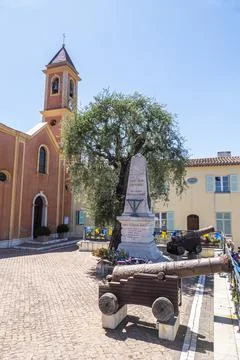 The main square of Saint Jean Cap Ferrat with a monument, an olive tree and o Stock Photos