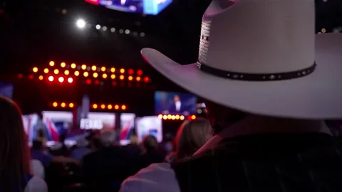 The main stage seen past a delegate in a cowboy hat, RNC Dallas 2026 Stock Footage 345271498