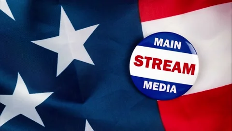 Main stream media text quote on election button laying on the star spangled b Stock Footage 170629651