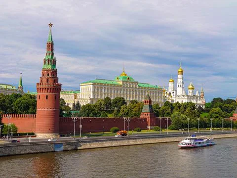 Main view of the Moscow Kremlin, street cleaning is underway, a pleasure boat is Stock Photos