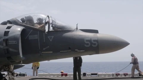 Maintainer gathering cable attached to AV-8B Harrier aboard USS Boxer Stock Footage 114001378