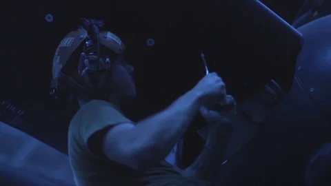 Maintainer loosening screw on panel of plane at night aboard USS Boxer Stock Footage 114001371