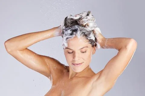 Maintaining her crown. Studio shot of an attractive young woman washing her hair Stock Photos