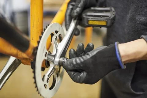 Maintenance of a bicycle: person disassembling an orange bike at his repair.. Stock-Fotos