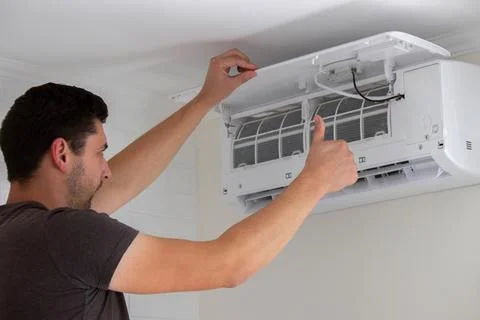 Maintenance Complete. Technician Installing Clean Air Filter in Air Condition Stock Photos