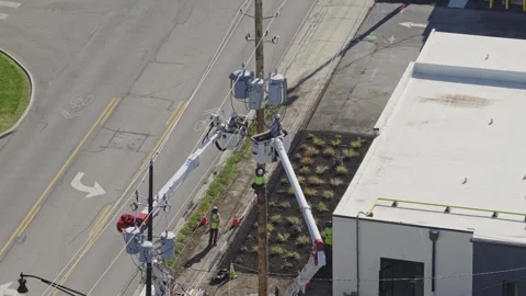 Maintenance construction crew repairing power grid bringing electricity online Stock Footage 343659300