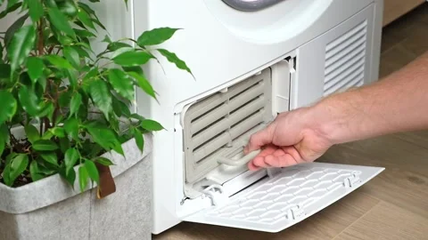 Maintenance dryer after drying cycle. Drying machine. Dirty filter dryer. Man Stock Footage 219751716