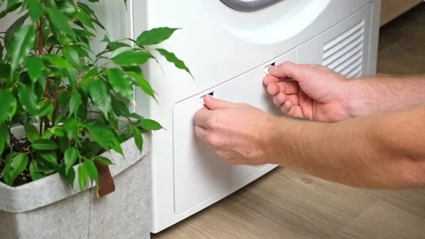 Maintenance dryer after drying cycle. Drying machine Man takes out dirty filter Stock Footage 220099788