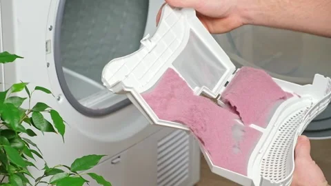 Maintenance dryer after drying cycle. Drying machine Man takes out dirty filter Stock Footage 220099881