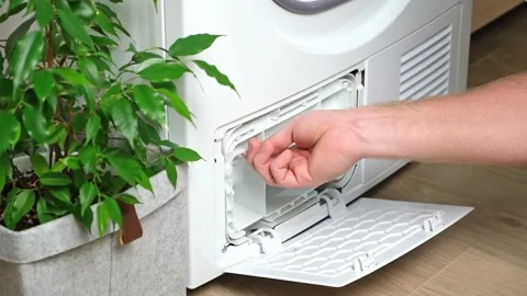 Maintenance dryer after drying cycle. Drying machine Man takes out dirty filter Stock Footage 220886097