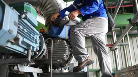 A maintenance electrician is checking the induction motor Stock Footage 164925325