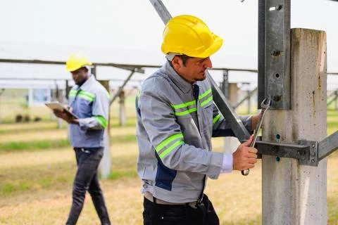 Maintenance engineer checking and maintaining solar panels on solar cell farm Stock Photos