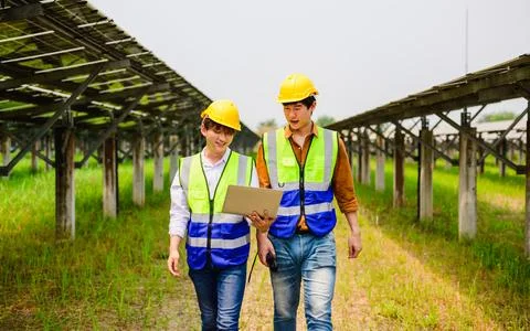 Maintenance engineer checking solar panels on solar cell farm Stock Photos