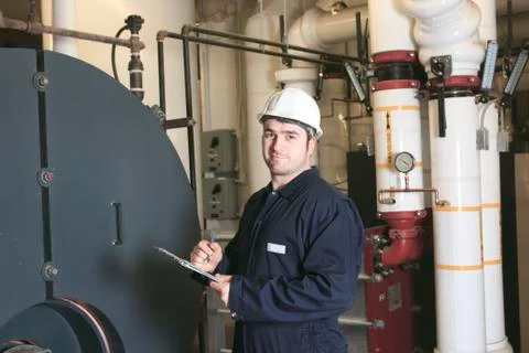 Maintenance engineer checking technical data of heating system e Foto stock
