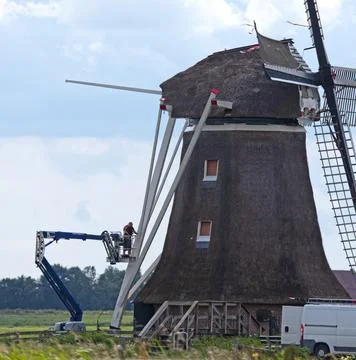 Maintenance engineer doing some work on an old windmill Stock Photos