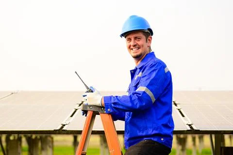 Maintenance engineer installing solar panels on solar cell farm 스톡 사진