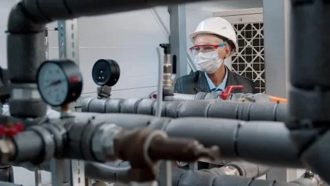 Maintenance engineer in safety mask checking technical data of heating system Stock Photos