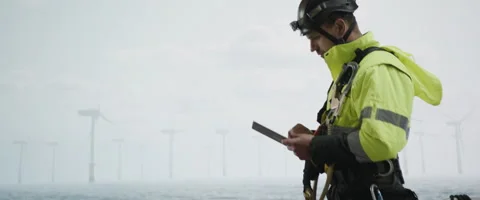 Maintenance engineer standing on a service vessel approaching offshore wind farm Stock Footage 245351519