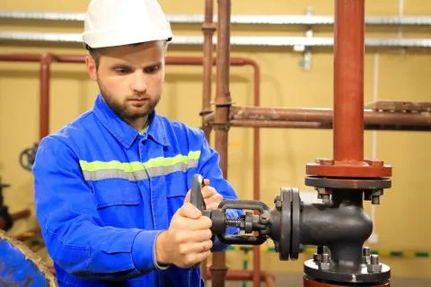 Maintenance engineer  turns a main valve and launch technological process Foto stock