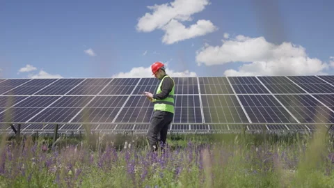 Maintenance Engineer Walking by the Solar Cells and Using Tablet on a Sunny Day Stock Footage 276164042