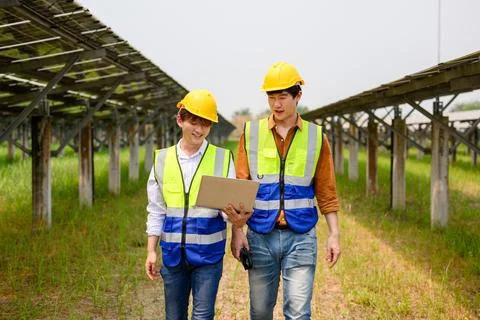Maintenance engineers checking solar panels on solar cell farm Stock Photos