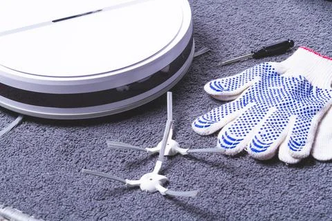 Maintenance of the robot vacuum cleaner. Replacement of brushes and filter... Stock Photos