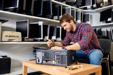 Maintenance of system unit. handsome cheerful man learning to repair computer Stock Photos