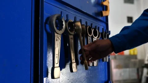 A maintenance technician selects a wrench from a tool cabinet.  動画素材 304067472