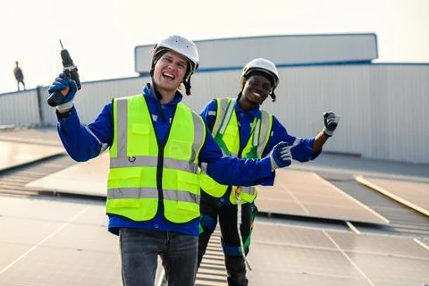 Maintenance technicians installing solar panels at solar cell farm 스톡 사진