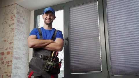 Maintenance worker in uniform, blue T-shirt and cap, crossing his arms. A 库存影片 233284813