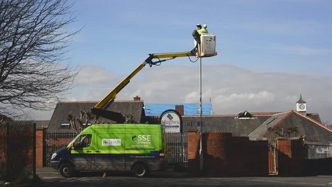 Maintenance worker using cherry picker to replace bulb in streelight uk Stock Footage 90374322
