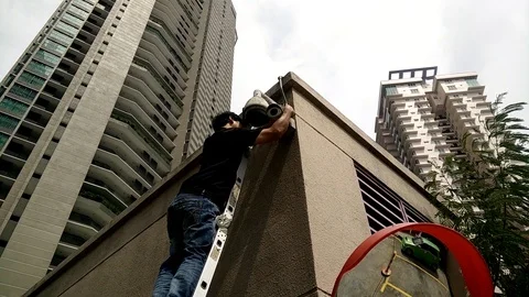 Maintenance workers are checking out CCTV cameras outside the building. Stock Footage 92898880