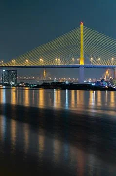 A majestic cable-stayed bridge radiates a golden luminescence against the t.. Stock Photos