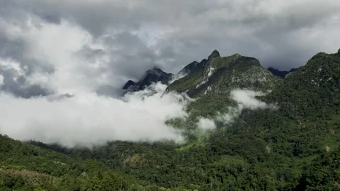 Majestic Clouds and Sunlight Over Lush Green Mountains Stock Footage 338372173
