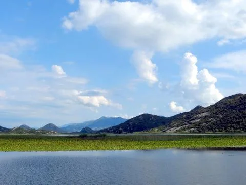 Majestic clouds float above the tranquil waters of Skadar Lake, reflecting th Stock Photos