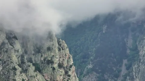 Majestic clouds gracefully drifting over a towering mountain peak Stock Footage 289675605