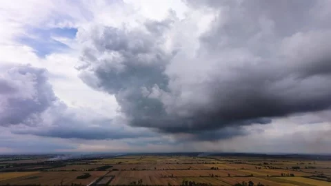 Majestic dark cloud formation hovering over expansive countryside landscape Stock Footage 337756942