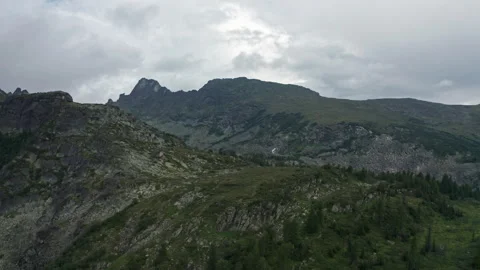A Majestic Mountain Range Embraced by a Dramatic, Cloud-Streaked Sky Stock Footage 257178345