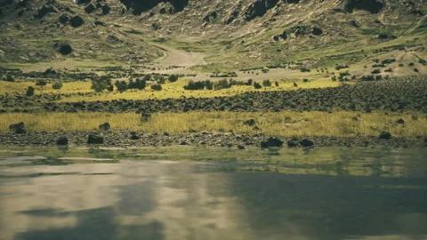 Majestic mountain range reflected in tranquil waters under gentle clouded sky Stock-Footage 341581038