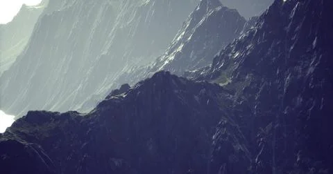 Majestic mountain range with rugged cliffs and dramatic lighting at dawn Stock Illustration