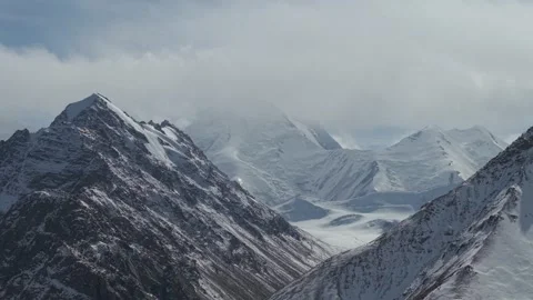 Majestic mountain range with snow-capped peaks, camera slowly zooms in Stock Footage 320395528