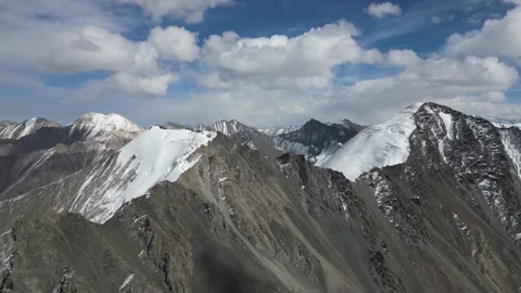 Majestic mountain range with snow-capped peaks, camera pans across landscape Stock Footage 325024162