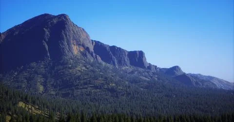 Majestic mountain range under clear blue sky with lush forest at the base Stock Illustration