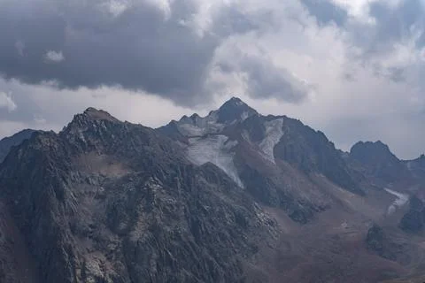 Majestic Mountain Range Under Dramatic Clouds with Glacial Features and Rug.. Stock Photos