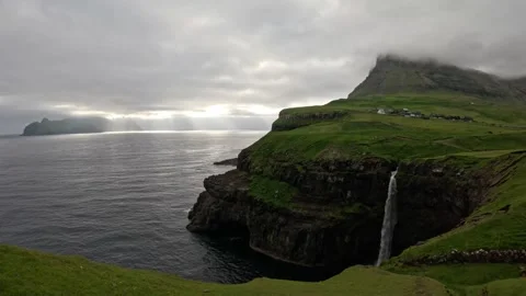 Majestic Múlafossur waterfall and dramatic sun rays over ocean, Faroe Islands Stock Footage 337558570