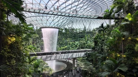 The majestic Rain Vortex pours down the center of Jewel Changi Stock Footage 315547789
